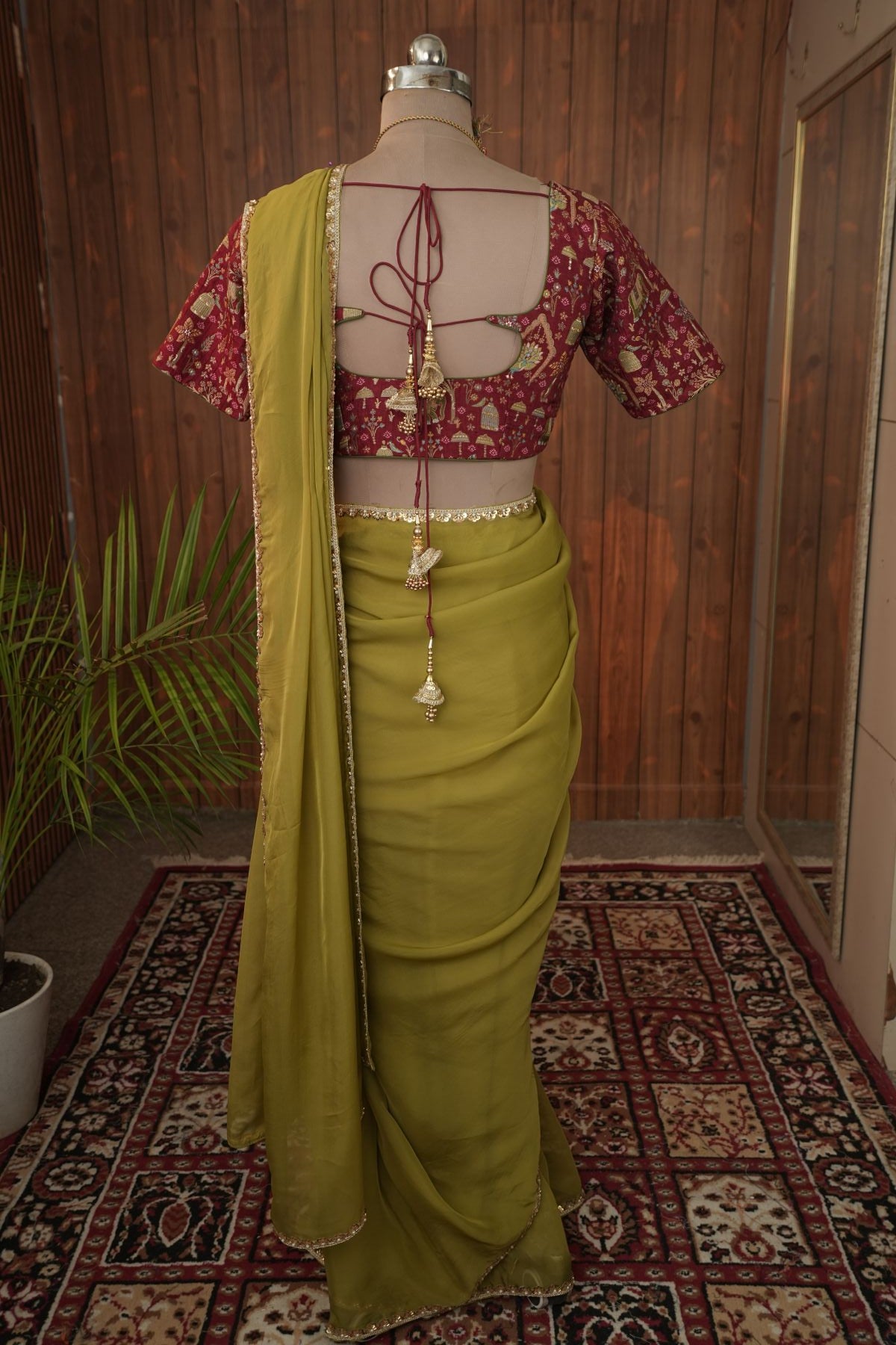 Back view of olive green saree and maroon tie-back blouse