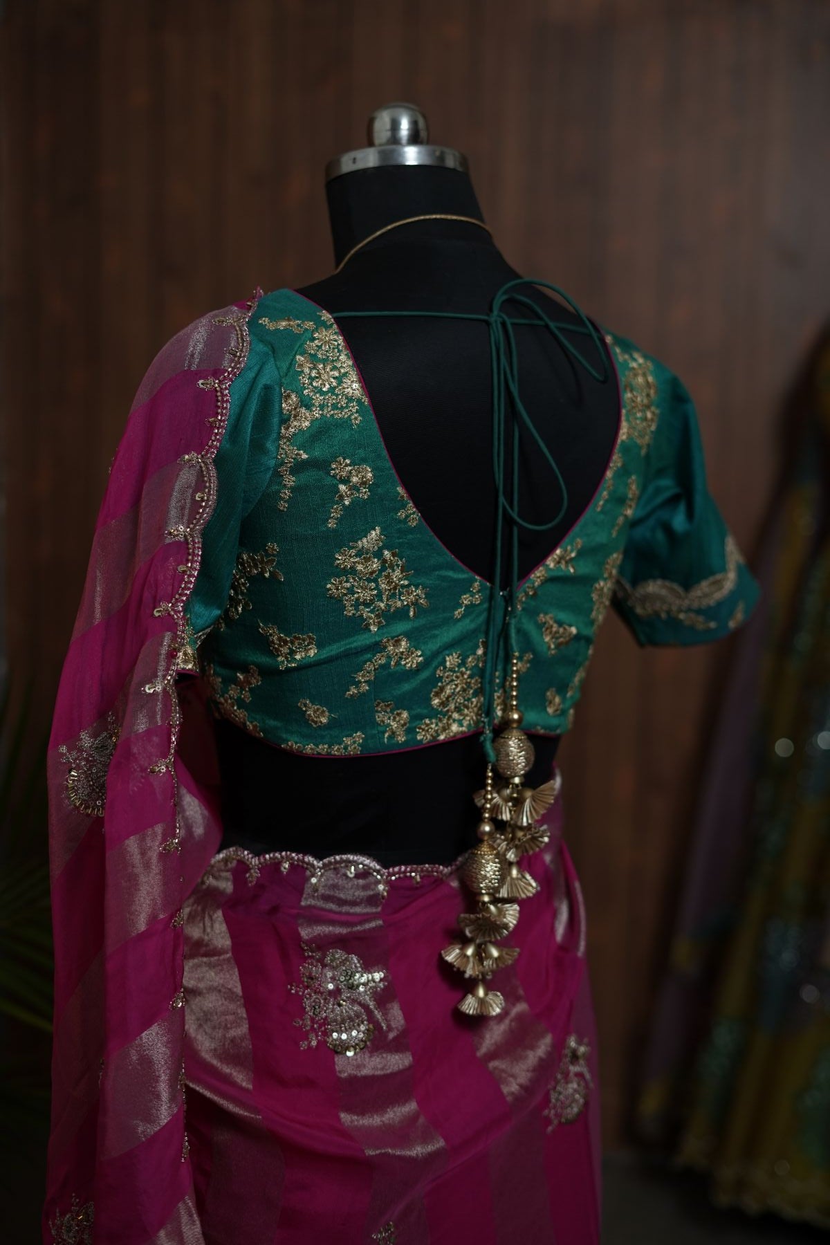 Back detail of saree styling with teal blouse and decorative tie tassels