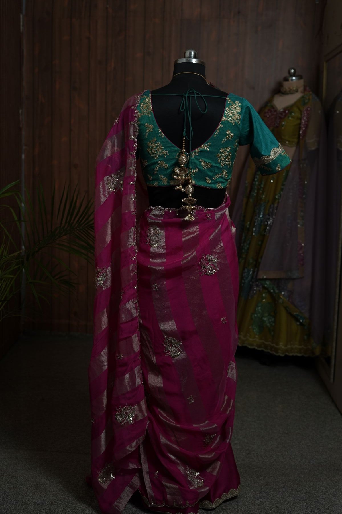 Full back view of magenta saree with embellished motifs and scalloped border