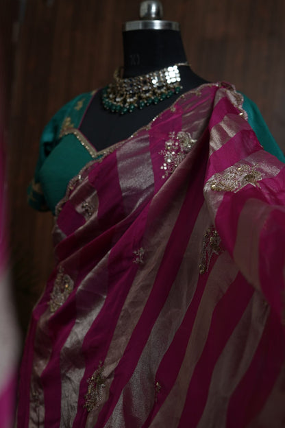 Close-up of metallic stripes and embellished motifs on magenta saree
