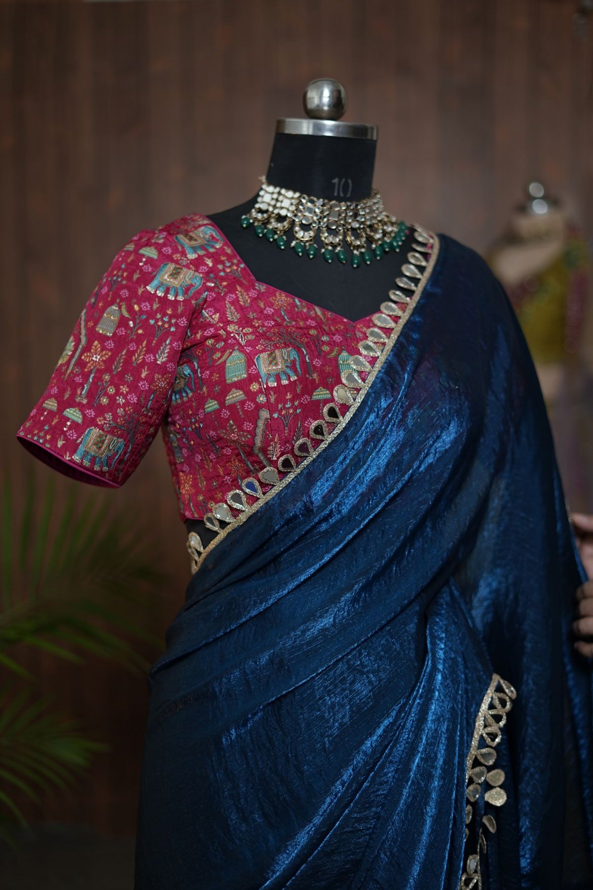Front detail of navy blue saree drape and patterned pink blouse