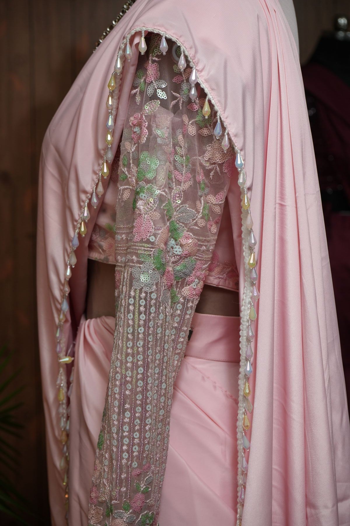 Front view of blush pink saree with layered ruffles and floral sequin full-sleeve blouse