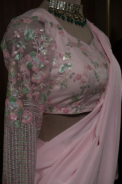 Back view of blush pink ruffle saree and blouse with sheer upper-back panel