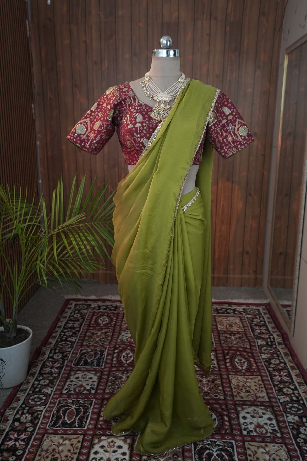 Close-up of olive green georgette saree border and maroon blouse