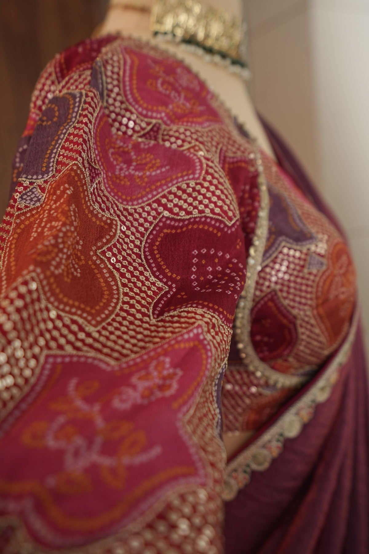 Back view of plum saree and blouse with deep back and tie-up tassels