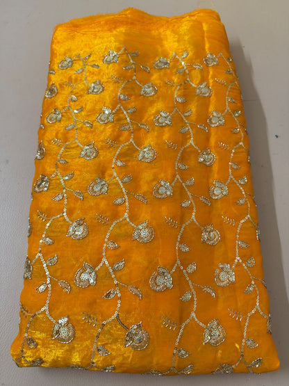 Full view of mustard-gold lehenga skirt with all-over floral metallic embellishment and ornate hem border