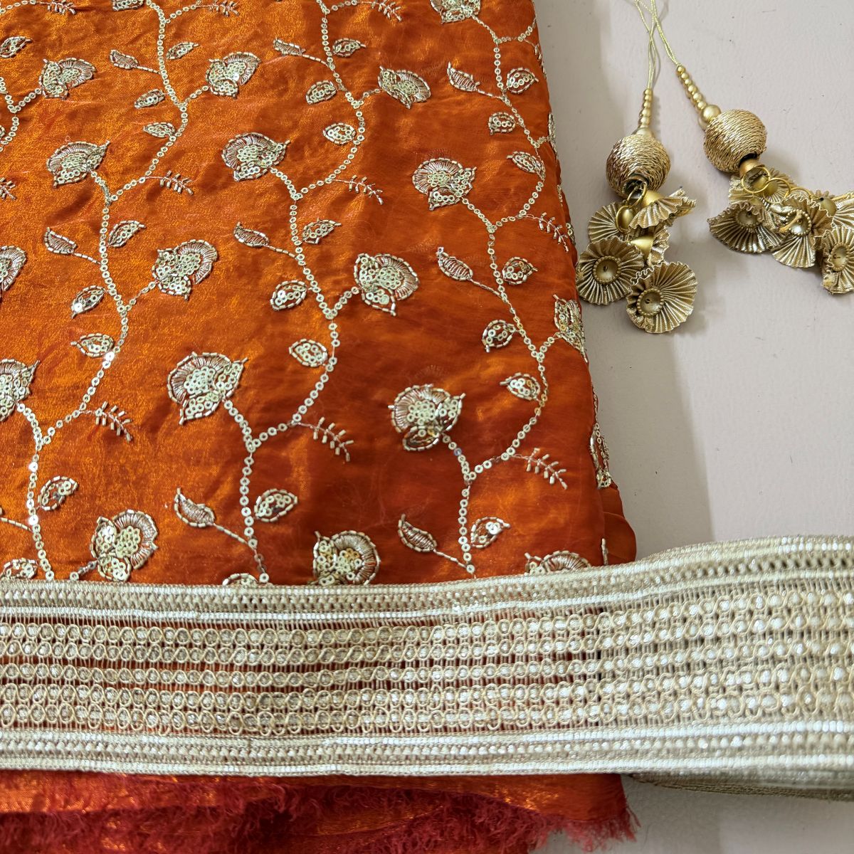Rust orange shimmer georgette lehenga with gold floral embroidery and gota border
