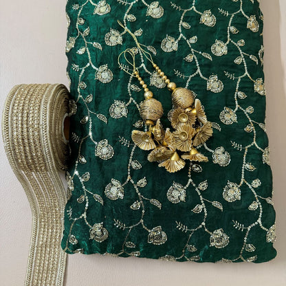 Close-up of teal green lehenga skirt embroidery, decorative latkan and embellished border