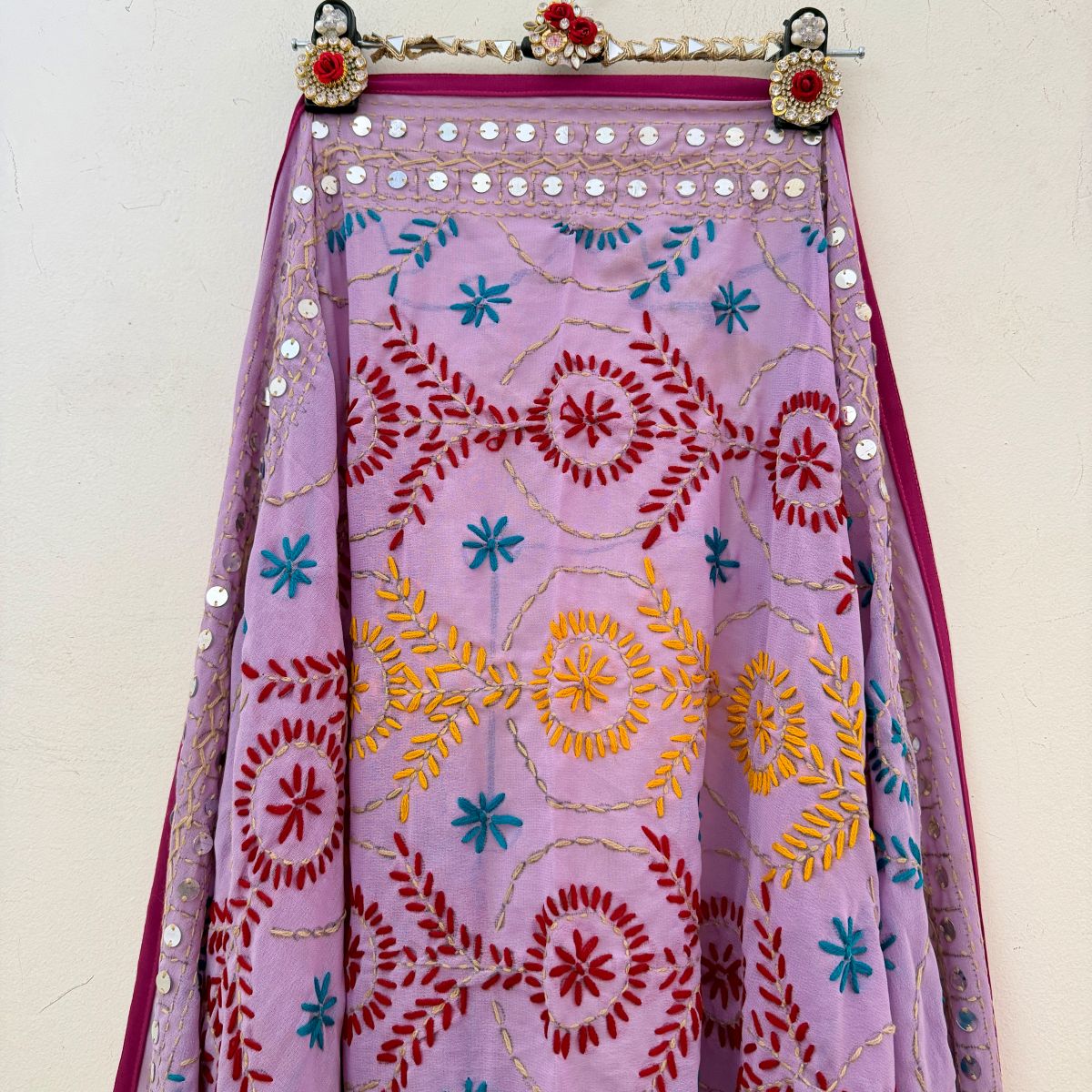 Close-up of beige Phulkari dupatta showing black hand-woven thread motifs and border