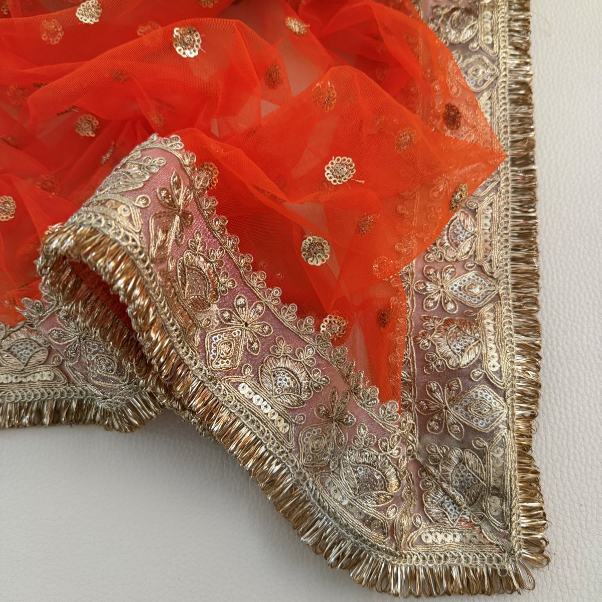 Draped orange embellished dupatta with gold-toned border