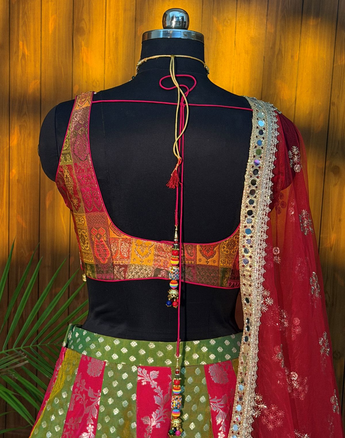 Front view of pink and green panelled lehenga set with blouse and sheer pink dupatta