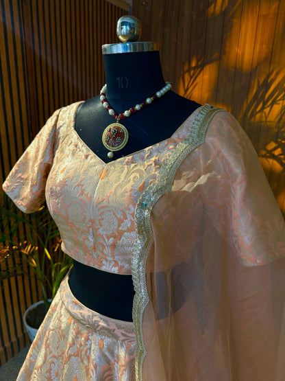 Close-up of brocade blouse neckline with scalloped gold trim and sheer dupatta drape
