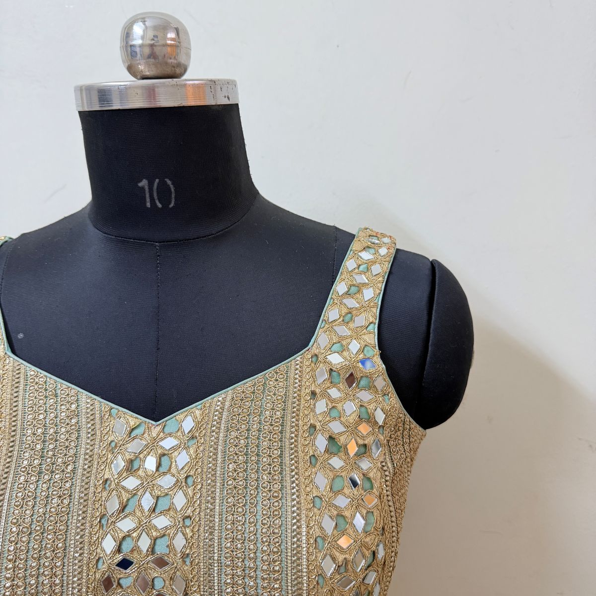 Close-up of gold embroidery and mirrorwork on blouse strap