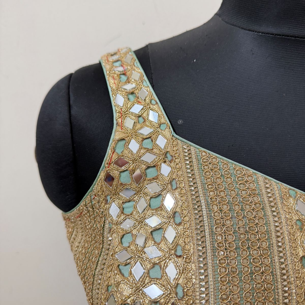 Neckline and mirrorwork detail of mint corset-style blouse