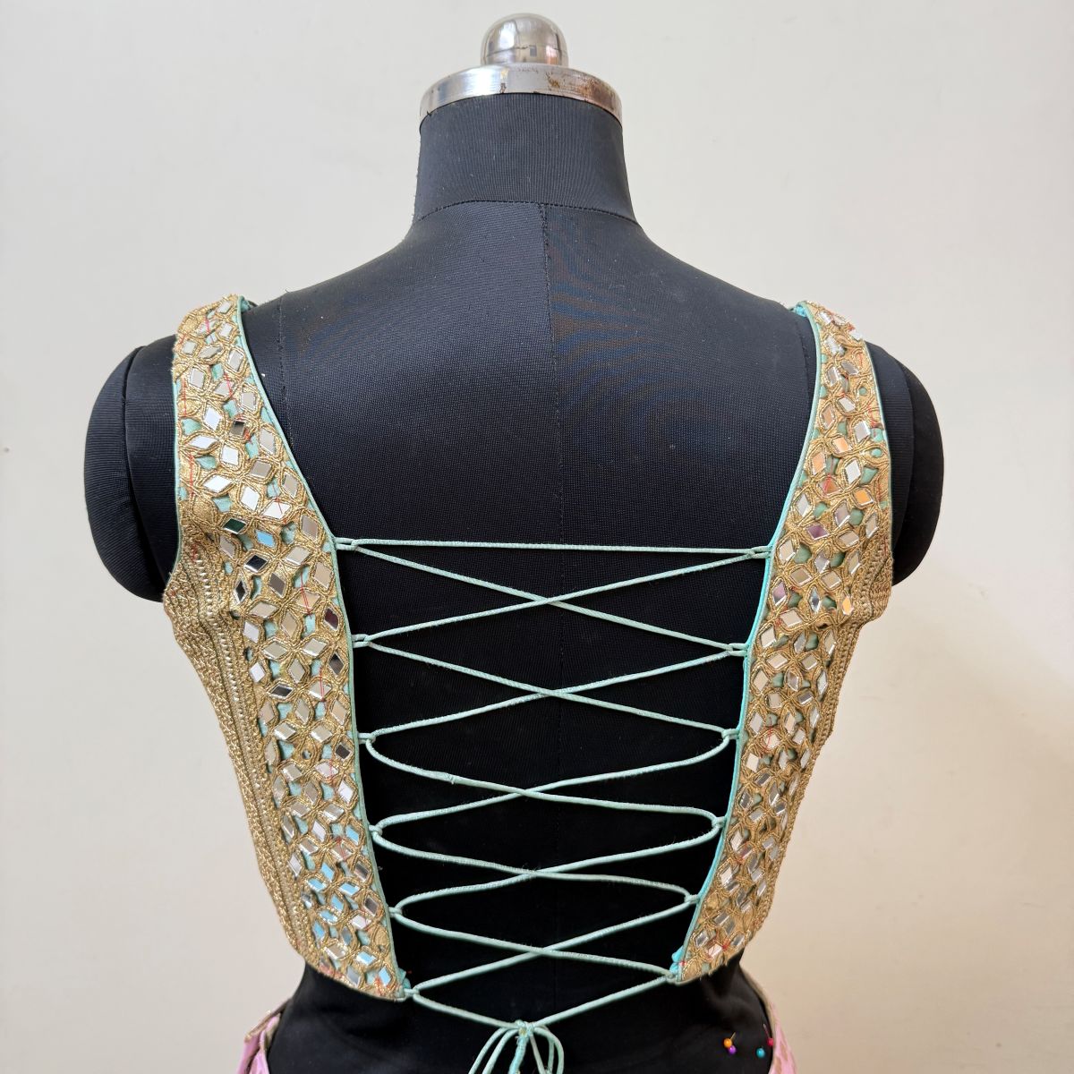 Open lace-up back of mint and gold blouse