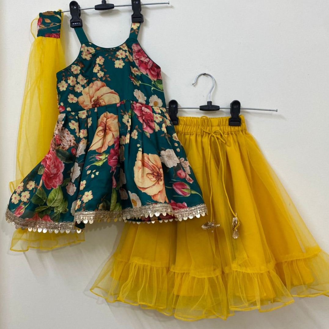 Floral dress with a yellow tulle skirt on hangers against a white wall