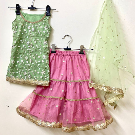 Green and pink traditional outfit with gold details on a white background